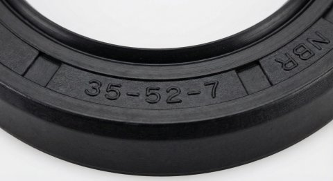 Standardowe oznaczenia wymiarowe wytłoczone na gumowym uszczelniaczu wału.