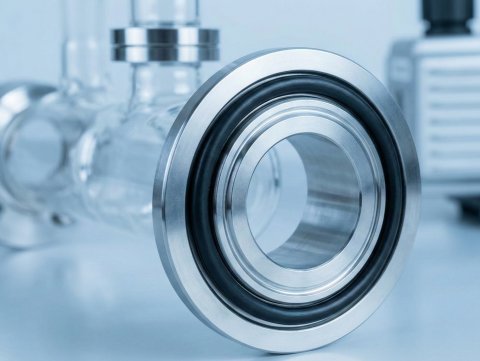 Czarny oring Viton FKM zamontowany na stalowym kołnierzu pompy próżniowej w laboratorium.